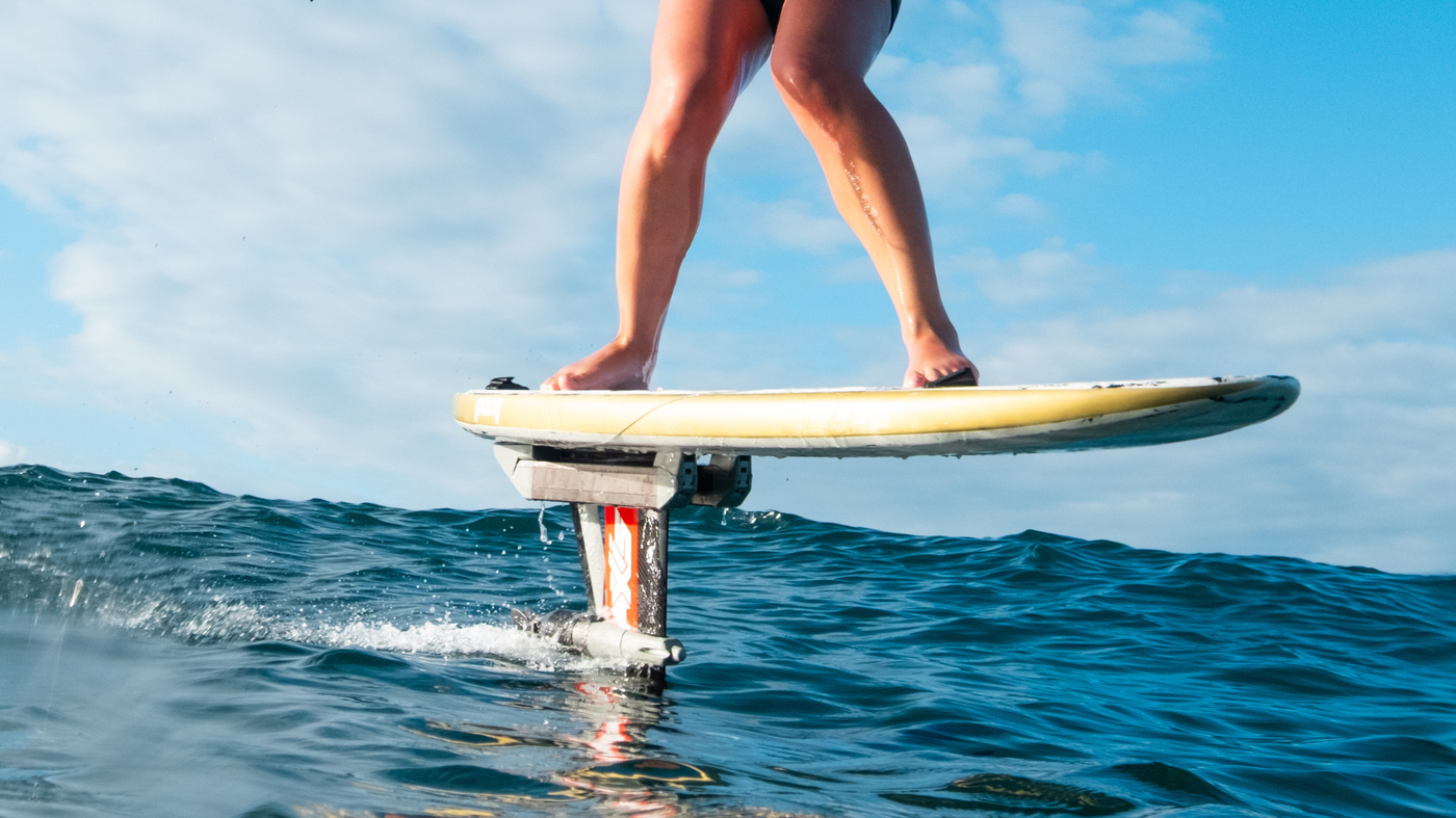 foiling with foil assist techniques for prone wing downwind on a surfboard in open water