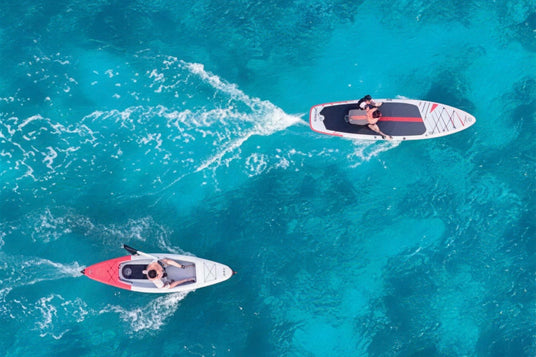 Aerial view of a rider paddling the Waydoo UniRide eKayak beside a UniRide Explore eSUP on clear turquoise water