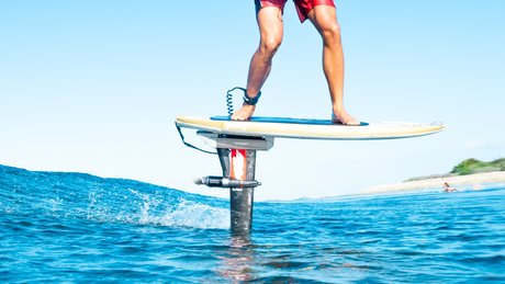 A person surfing on a foil with visible thrust, highlighting foil assist thrust requirements.