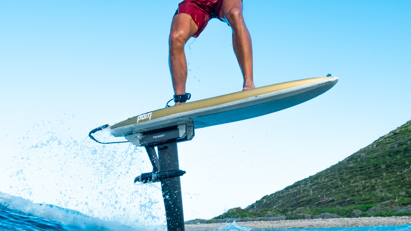 FoilBoost vs Foil Drive: A Spec-by-Spec Comparison for Serious Foilers with a surfer riding a hydrofoil.