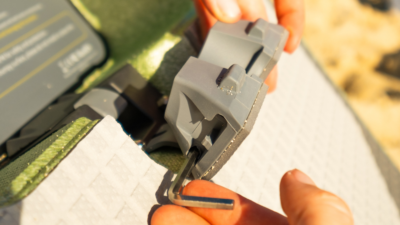 SUP motor kit installation: Subnado quick-release mount being fitted to a paddle board with a hex key